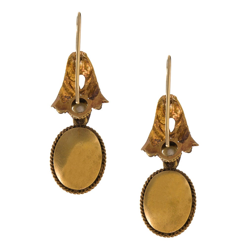 Feminine Victorian earrings, offering a soft combination of golden leaves, sweet pearls and cabochon rock crystal, foiled in pink and framed in braided gold. Made of 18k yellow gold and measuring 1.25 inches long.