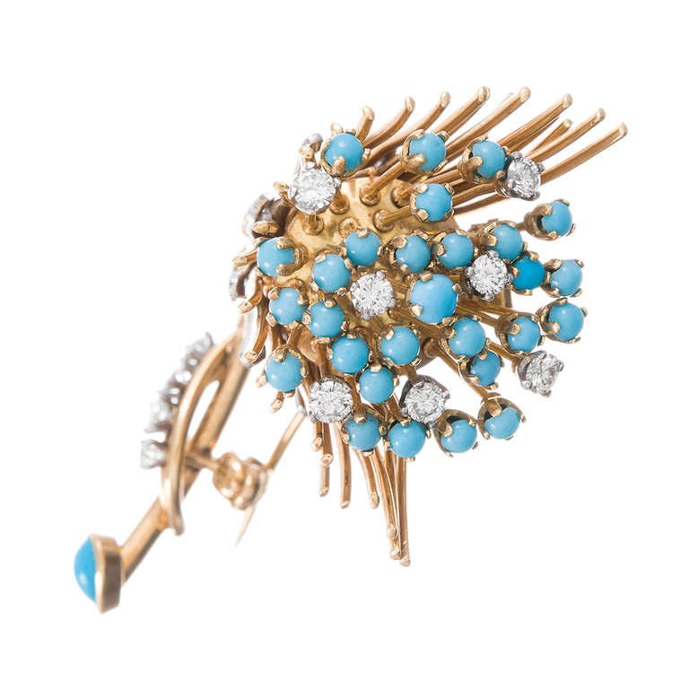 Charming and unique brooch, clearly a flower motif, et abstract in its design, made of platinum and 18k yellow gold and decorated with turquoise, diamonds, rubies, sapphires and an emerald. The 