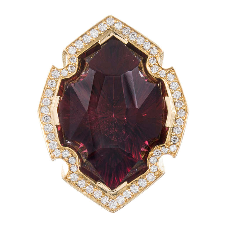 Very unique and distinctive style, with a custom-cut red tourmaline nestled in a stylized diamond bezel. The ring rises 16 mm off the finger, which makes a bold statement, but also allows space to appreciate the geometric enamel designs, inlaid