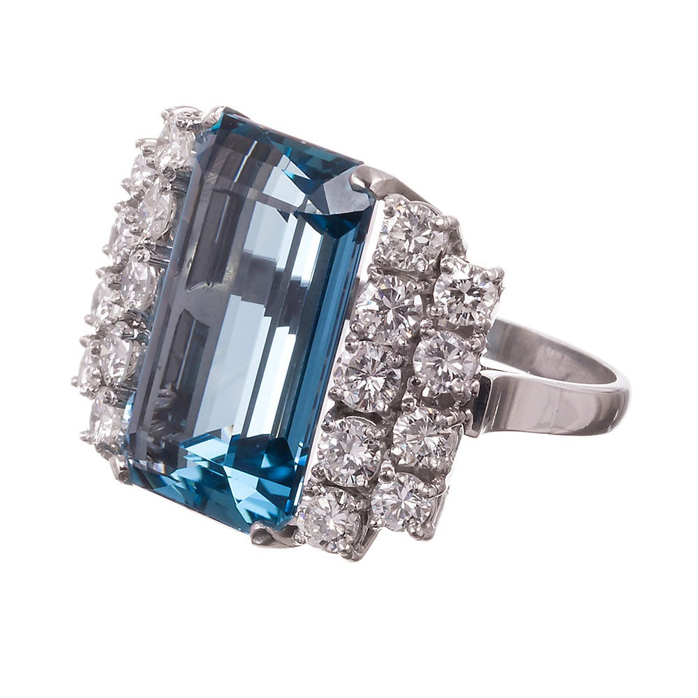 Set in platinum, this ring artfully stacks together rows of diamonds to frame the major aquamarine center. The bright brilliant diamonds enhance the superior color of the aqua and lift the stone up with an impressive pop! This is among the finer