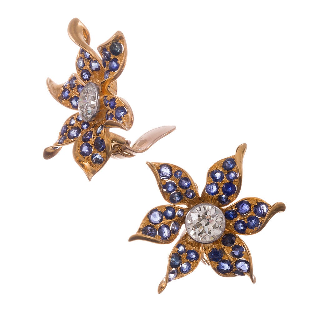 Lifelike flower earrings, the petals sparkling with intense blue sapphires and the centers set with substantial brilliant round diamond solitaires. The diamonds weigh 3.50 carats in total and grease as G color and Vvs clarity. Measuring 1.25 inches
