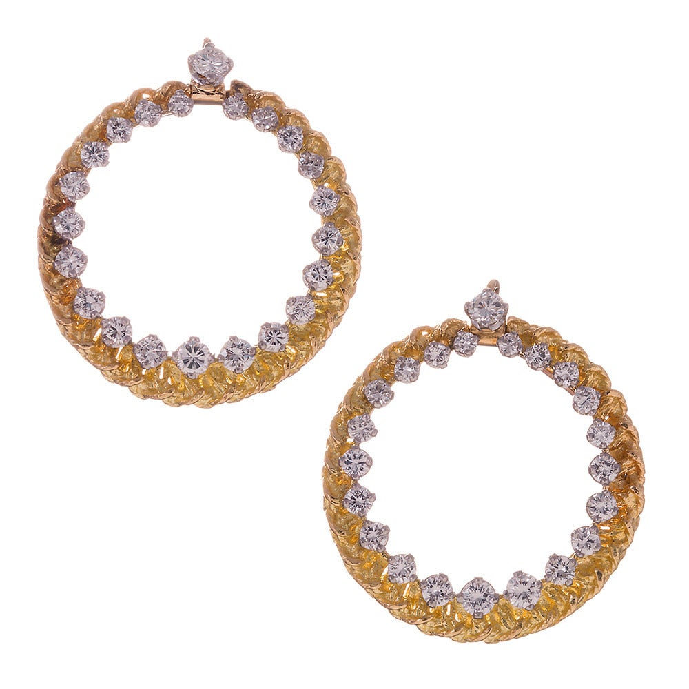 18k yellow gold earrings, a braided design of textured rope, highlighted with brilliant white diamonds. The bottoms can be detached from the tops, allowing for a subtle asymmetric hoop. Add the bottom enhancer for a dramatic upgrade. 2 3/8 in