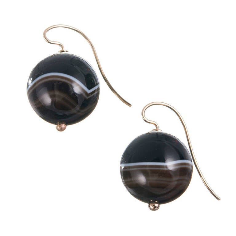 21mm banded agate balls are suspended from 14k yellow gold ear wires, dropping a total 1.25 inches. These simple creations offer organic charm, lovely color contrast and genuine wearability with a unique look.
