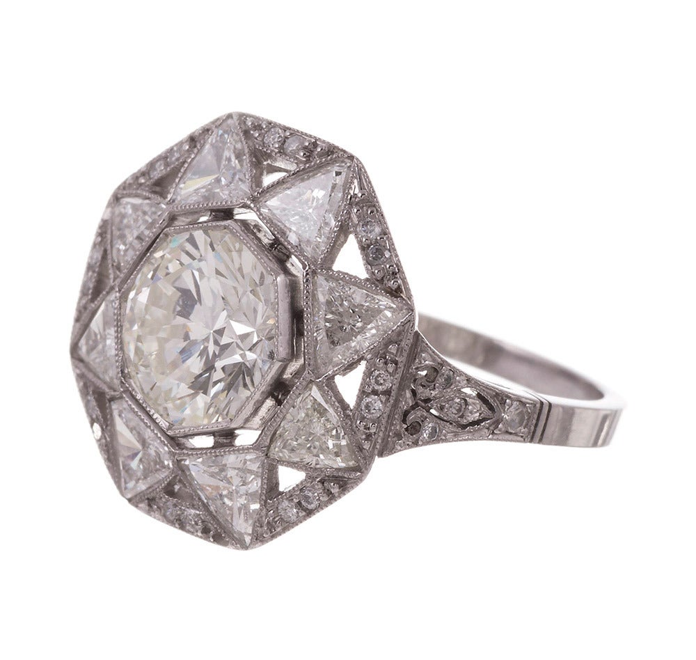 Unique and exceptionally beautiful, this hand made ring was clearly inspired by the celestial body that gives us light. The center is set with a 1.78 carat brilliant round diamond that we grade as K color and Vs2 clarity. Radiating from the center