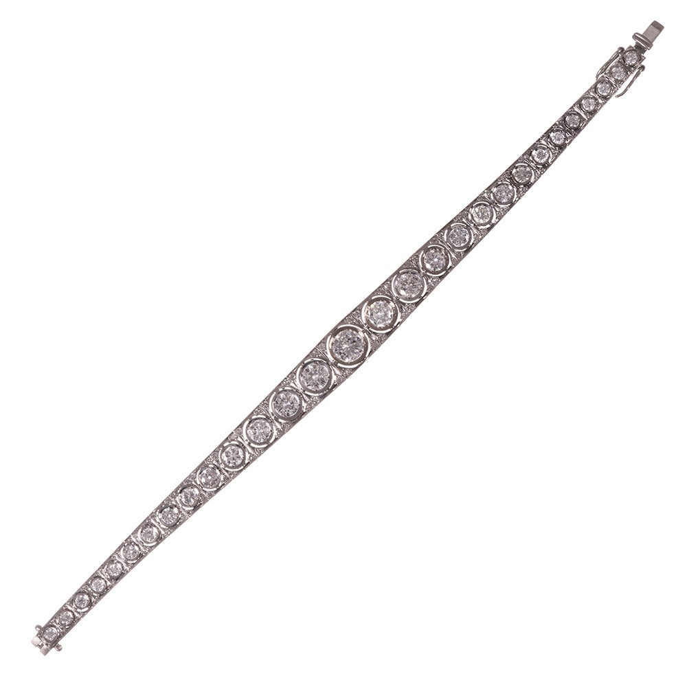 Measuring a hint under 7 inches in overall length and set with approximately 6.07 carats of brilliant round diamonds. The major stones are bezel set and graduated in size, with the largest weighing .85 carats. Each diamond is set in its own block,