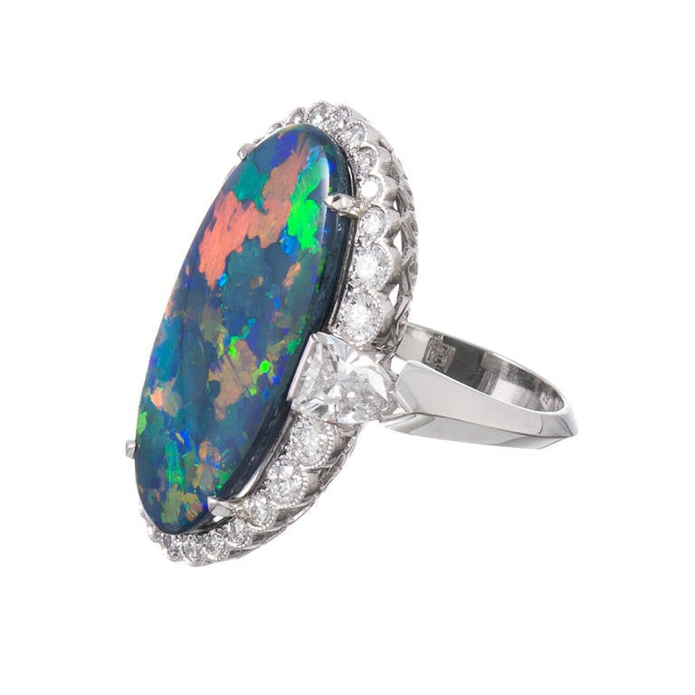For she who wishes to possess only the finest examples, we offer this magnificent opal and diamond ring. Opals from the lightening ridge mine are known for their exceptional properties and play of color, with intense red flashes and absolutely