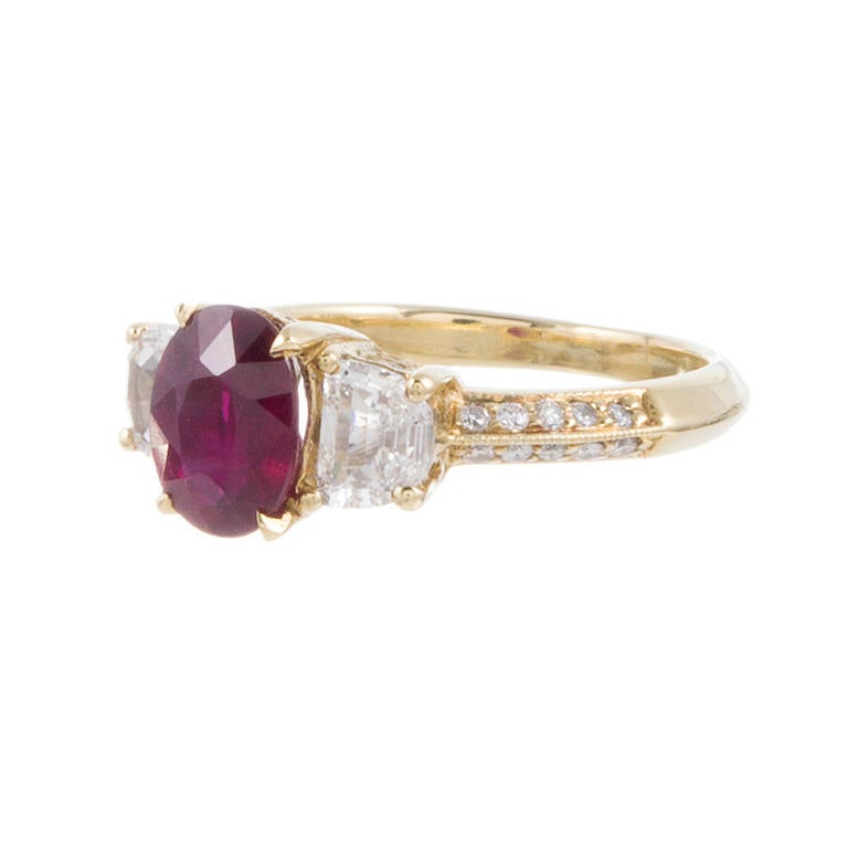 For the forever romantic, an intense, deep red oval ruby is nestled between two half moon diamonds and set in a diamond-crusted 18 karat yellow gold mounting. The ruby weighs 1.52 carats and the ring contains a further .70 carats of brilliant round