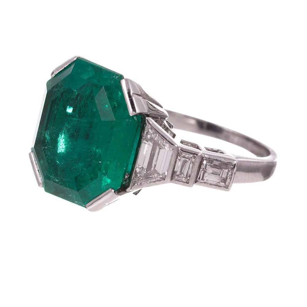 Stunning important art deco ring rendered in platinum and set in the center with an octagonal emerald weighing 7 carats. The major center stone is GIA-certified of Colombian origin and is complimented mixed cut diamonds set on the shoulders of the