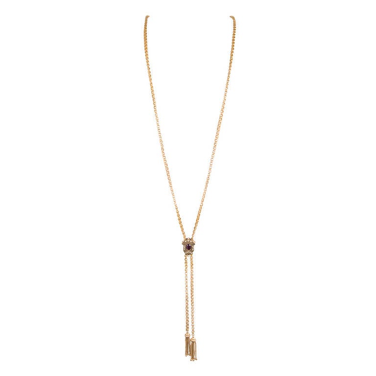 14k yellow gold, made in the USA circa 1880, woven links of gold with a single slide decorated with a garnet and seed pearls. Finished with a pair of golden tassels. 37 inches in overall length.