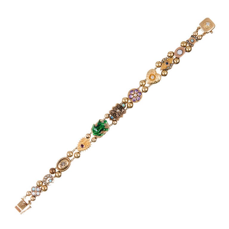 Assembled in the 1950s from Victorian charms originally made in the late 1800s, slide bracelets are a cult classic among antique jewelry enthusiasts. This one is made of 14k rose and yellow gold and combines eleven unique slides and a clasp