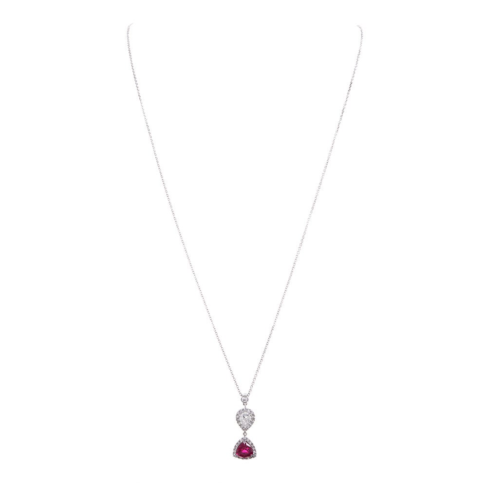 Contemporary style necklace, with a playful pairing of geometric gemstones. A 1.57 carat ruby and a .50 carat pear diamonds, each framed by brilliant white diamonds and suspended from a single diamond bale. The pendant drops one inch form the chain.