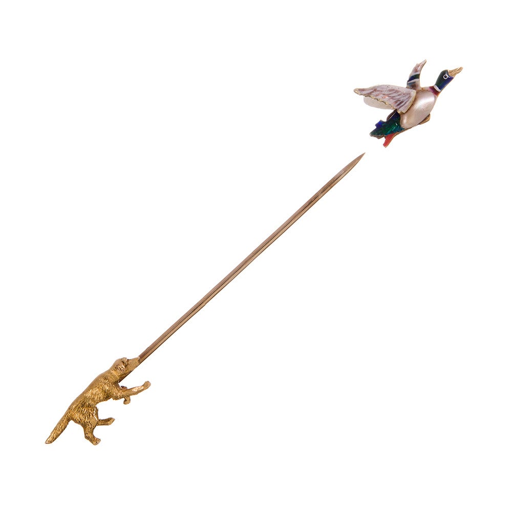 Crafted of 15k yellow gold and made in the United Kingdom around the turn of the century, this charming stick pin depicts a hunting dog chasing an enamel duck. At 3 inches in overall length, this would make a lovely decoration for a lady's lapel or