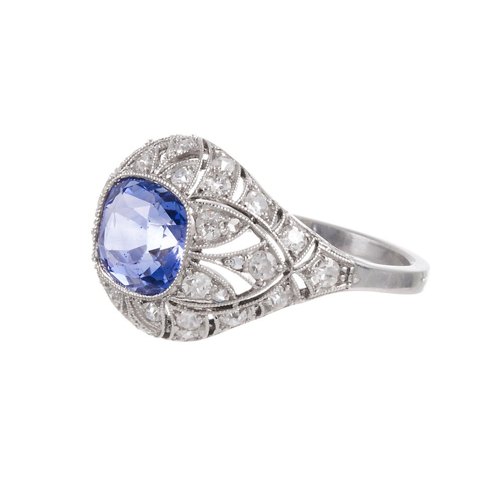 Genuine art deco splendor with a very finely detailed hand made platinum filigree mounting, set in the center with a 4.50 carat cornflower blue Ceylon sapphire. 38 old European cut diamonds weigh a total of .75 carats are peppered in nooks of
