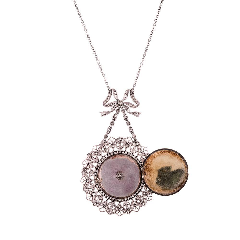 18k white gold medallion style pendant, suspended from a diamond-studded
bow and exuding femininity at every opportunity, this highly decorated
piece is a marvel of craftsmanship largely lost in modern jewelry and will
grace the neck of its owner