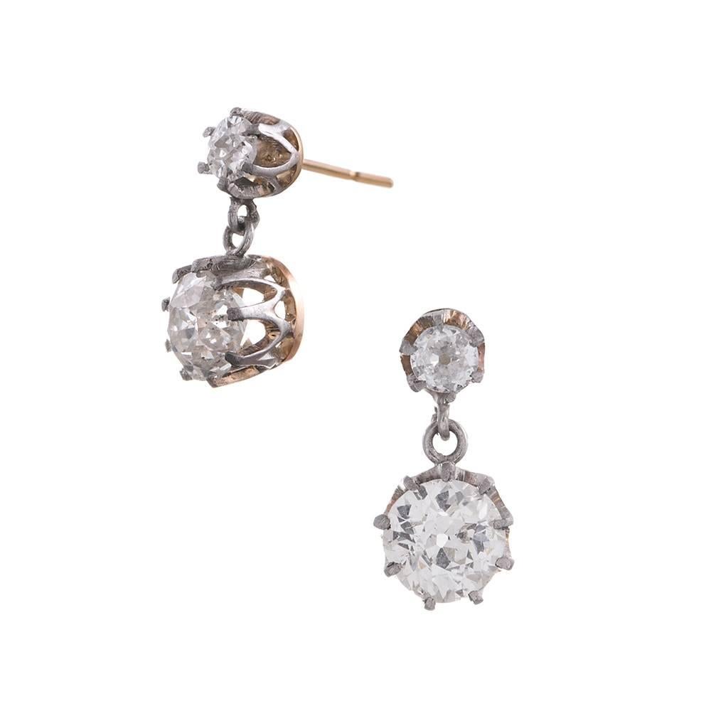 Turn of the century earrings hand made of platinum and 18k yellow gold, with claw-set old European cut diamonds. A pair weighing .18 carats in total anchors the top, while a pair weighing 1.05 carats combined trembles at the slightest movement,