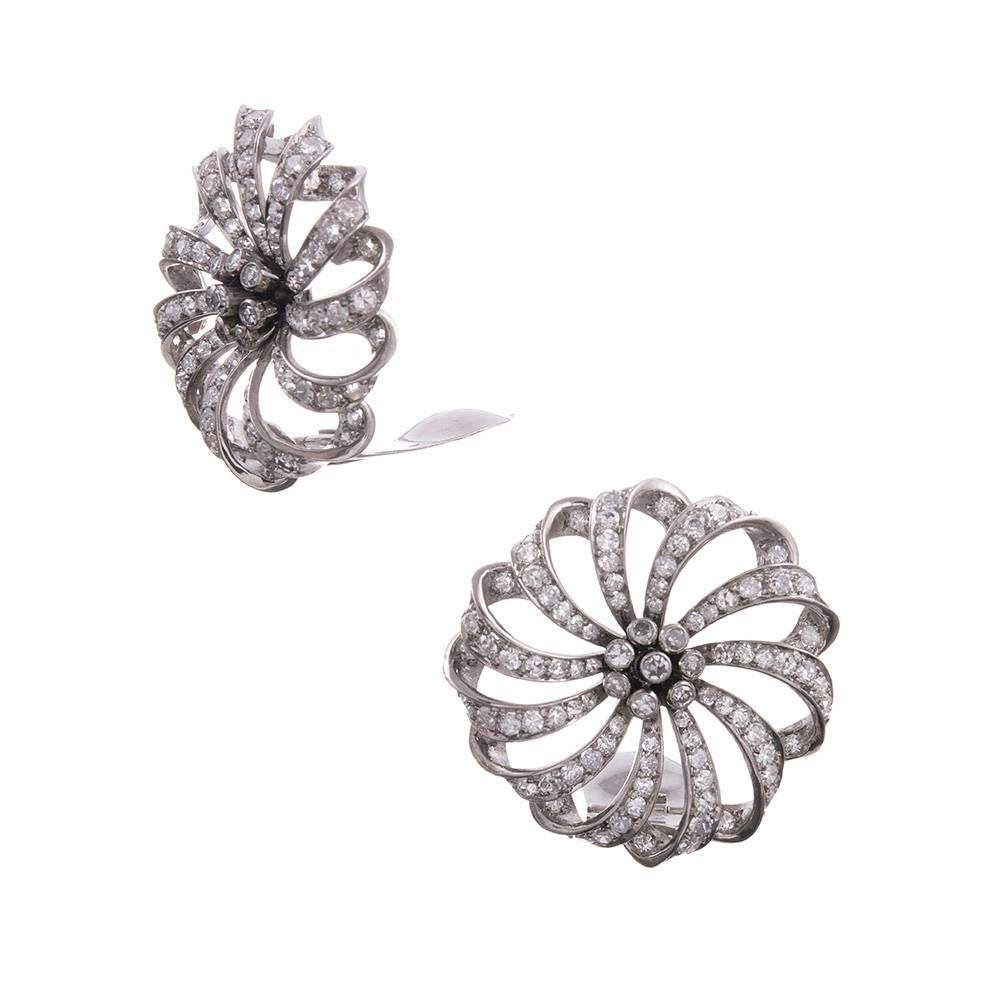 Made by hand in platinum, these three dimensional beauties are designed as rows of single cut diamonds- 211 in total- resembling a ribbon tied into an ornate bow and anchored in the center by a cluster of diamonds. The diamonds grade as G-H color