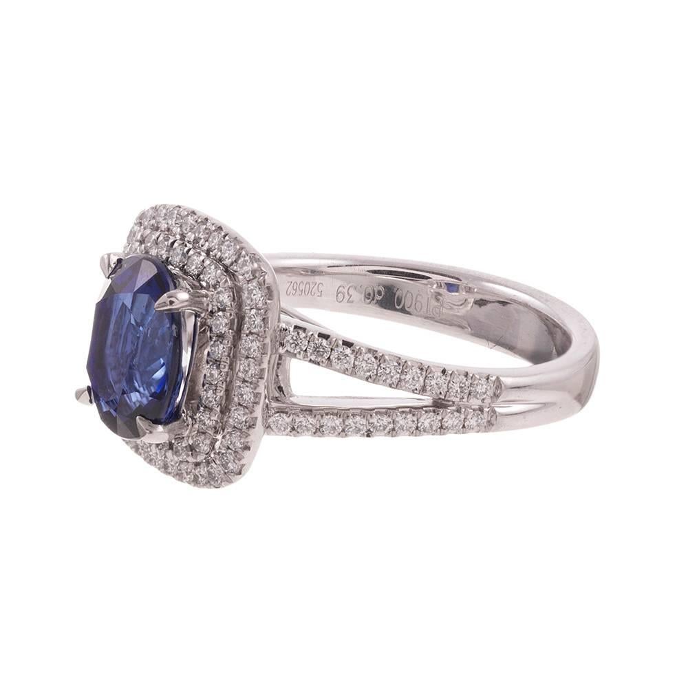 Rendered in platinum, this ring doubles the classic halo style that has become so beloved and creates a double frame of brilliant white diamonds around the center stone. The sapphire exhibits beautiful and intense transparent blue color and weighs
