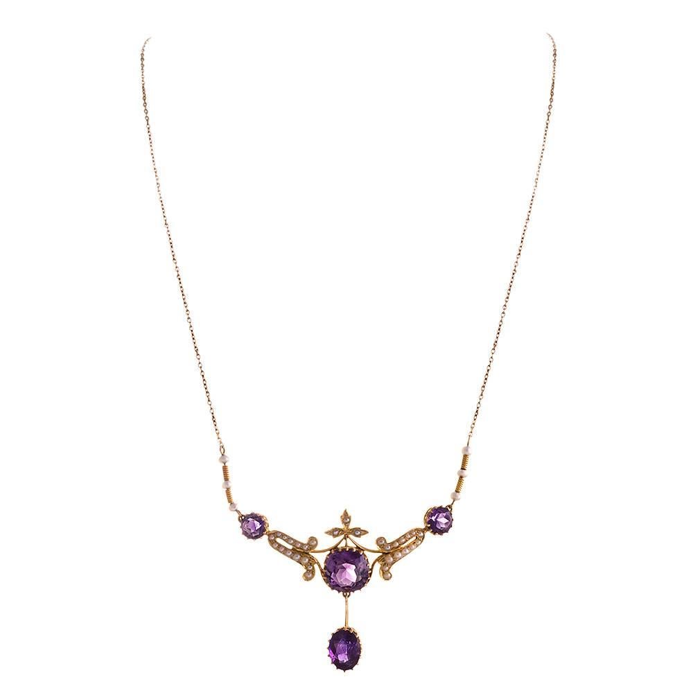 Lovely late Victorian rendering of fine jewelry, with amethyst & seed pearls. The brightly-colored gemstones beg for attention, while the pearls keep the design demure. The center section of the necklet measures 2 inches wide and drops 1.5 inches.