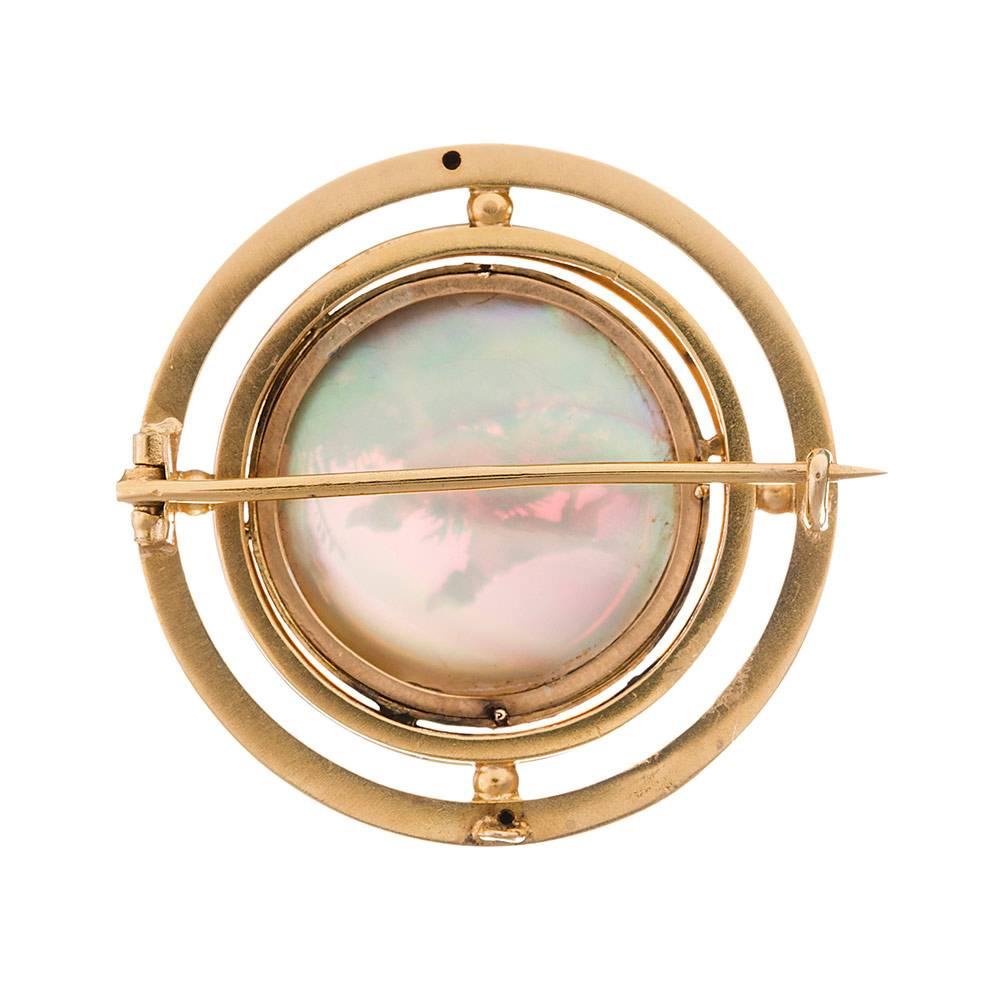 Triple frame of 18 karat yellow gold bordering a three-dimensional depiction of two dogs, noses lifted to catch a scent from the air, shown with a mother of pearl background and a displayed with a lovely landscape in the distance. Reverse painted