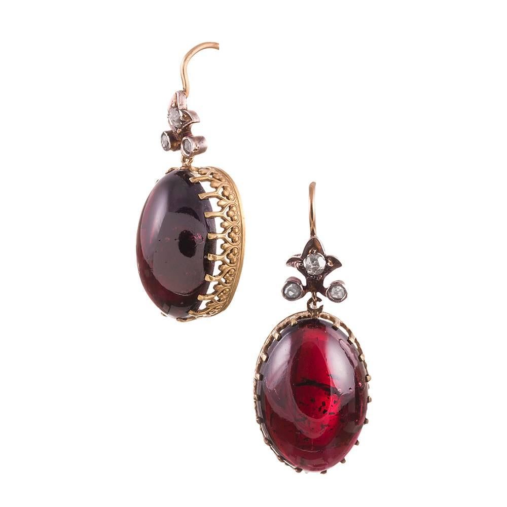 Lovely cabochon garnet earrings, topped with a flour-de-lys shaped finial and decorated with rose cut diamonds. These earrings are beautiful from every angle, with a detailed crownlike setting that is best appreciated form the side. 1.25 inches. 15k