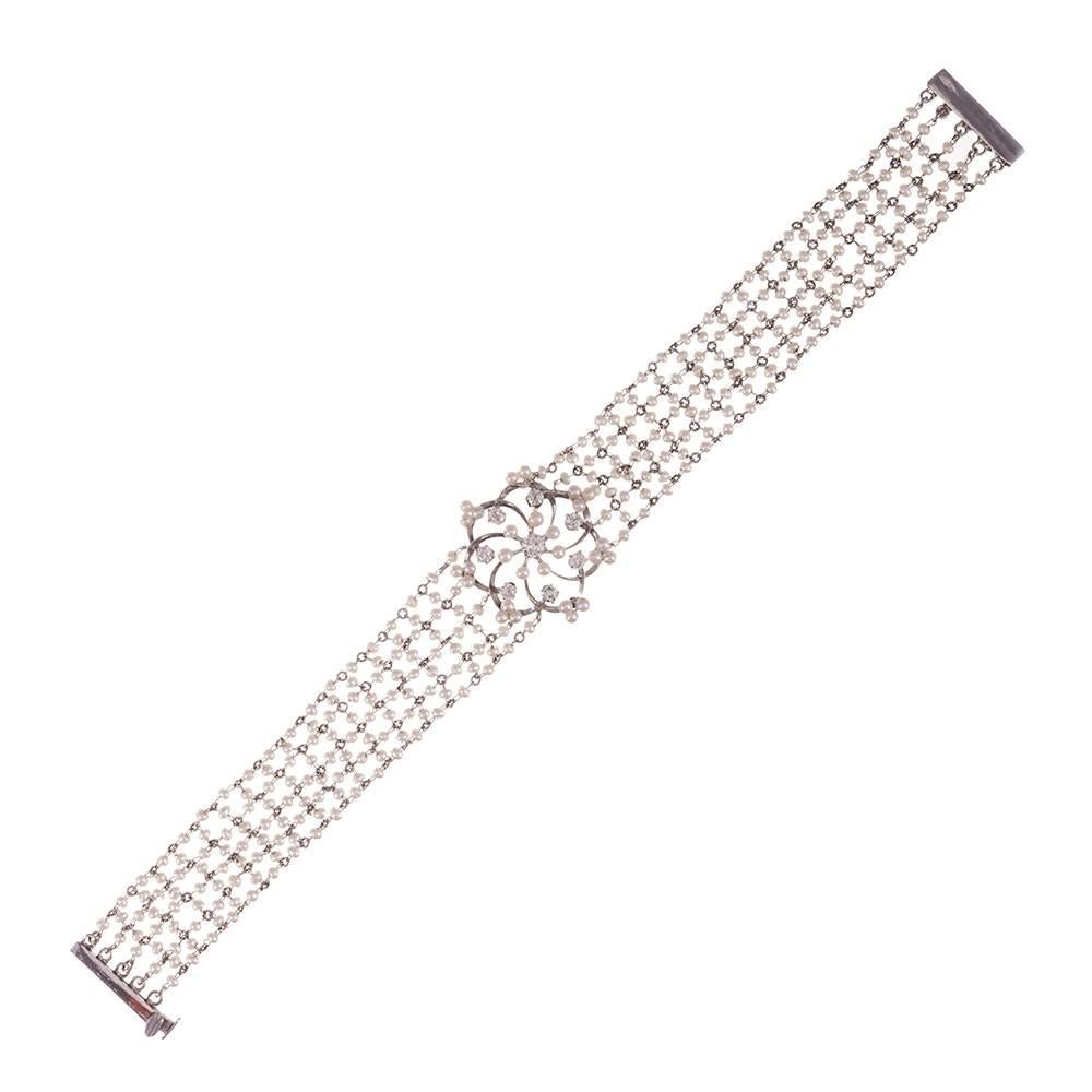 Hand-woven platinum wire creates a net of seed pearls and finished with a sunburst motif station at the center. In total, there are .75 carats of diamond accent stones. This piece exudes feminine charm and would be ideal for a bride to wear on her