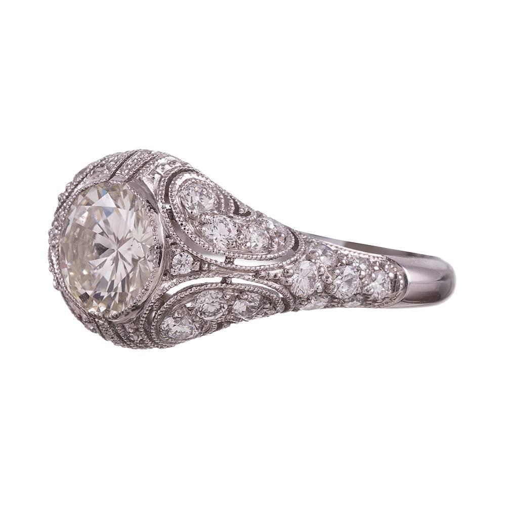 A hand made platinum creation combining style elements of the 1930s art deco era with the swirling strokes of 1940s retro. The “cherry on top” is the 1.80 carat brilliant round diamond. This ring is accompanied by an IGI appraisal report describing