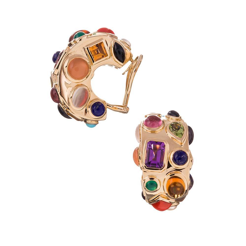 A playful take on classic hoop earrings, compliments of iconic American jeweler Seaman Schepps. Faceted and cabochon gemstones of every color and mineral are a symbiotic bold color combination with a backdrop of 18k yellow gold. 1 inch tall and