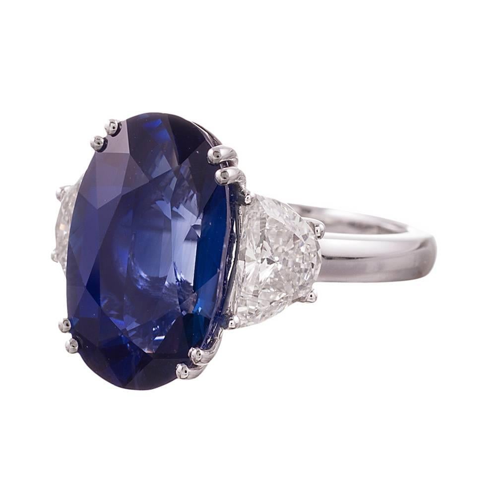 A gorgeous rendering of a classic three stone ring and one that looks particularly well on the finger. The elongated shape of the oval sapphire is very complimentary on a  feminine hand and tapers down beautifully with the half moon diamonds on each