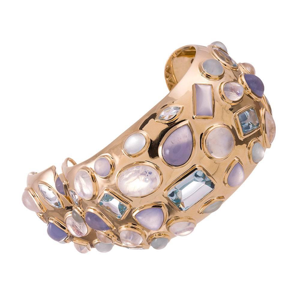 An instant classic, compliments of iconic jewelry designer Seaman Schepps. The high polished 18 karat yellow cuff is adorned with cabochons of chalcedony, moonstone, aquamarine and blue topaz. The colors are soft, feminine and oh so symbiotic as a