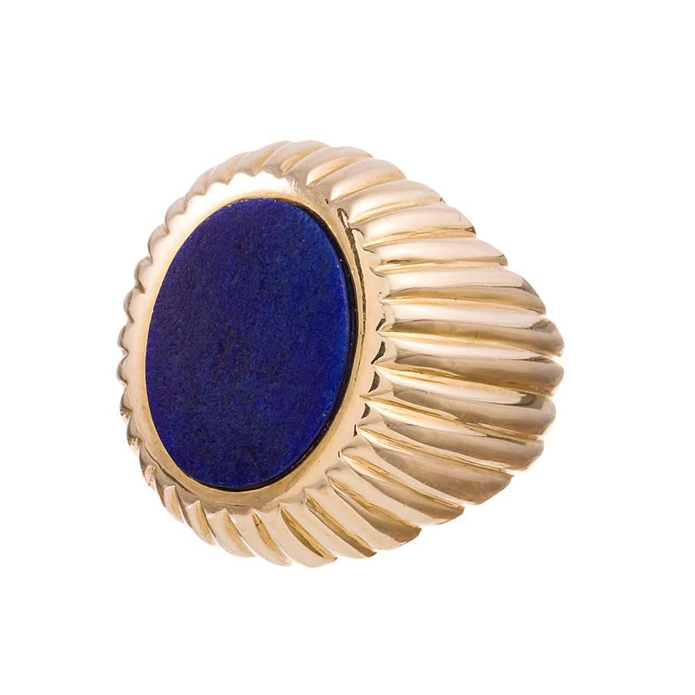 18 karat yellow gold gentleman’s ring designed as a raised platform of golden stripes radiating from the center lapis lazuli platform. The pattern continues around the bottom of the band in a flowing pattern, creating a lovely three dimensional
