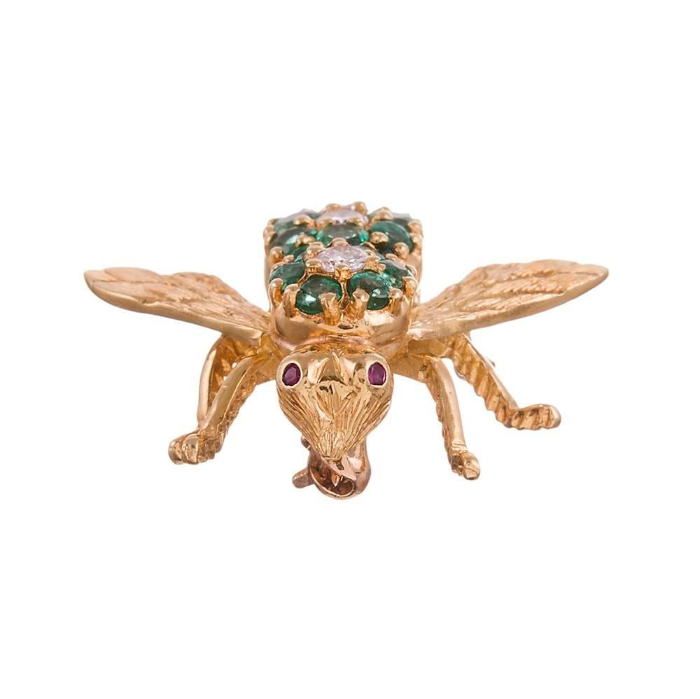 A sweet and whimsical bee, made of 18 karat yellow gold and set with emeralds and diamonds- 1 carat and .25 carats respectively. Look closely and note the ruby-set eyes and textured wings. This pretty little beauty can be worn on your lapel, sleeve