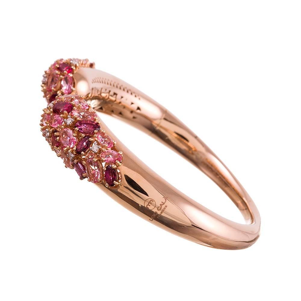 18 karat rose gold cuff bracelet, the tips set in a teardrop shaped collage with pink topaz and peppered with diamonds. The gemstones weigh 13.29 and .26 carats respectively. The rose gold creates a warm backdrop for the soft, feminine pink color