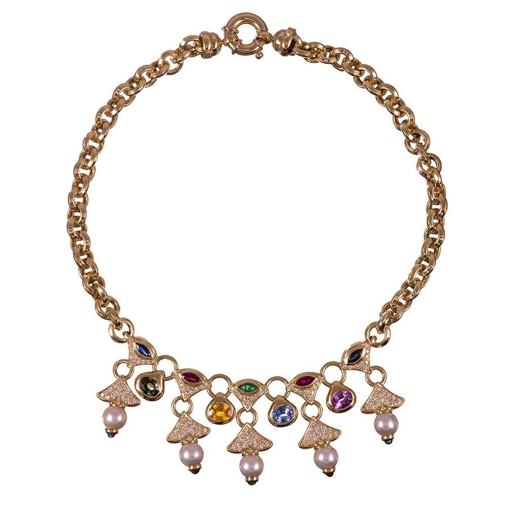 A 16 inch long three-dimensional chain is the backdrop for five fringing drops of diamonds and sapphires, each cascade punctuated by a pearl. This necklace bears striking resemblance Bulgari designs, yet is not signed. The combination of colored