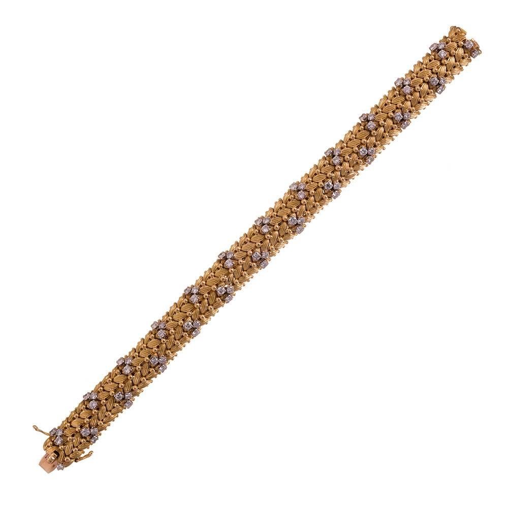 7.25 inches of masterfully crafted 18k yellow gold, woven into soft wheat like braids, peppered with golden dots and finished with trio clusters of brilliant diamonds, 3.84 carats in total. Offering a lovely hand and subtle organic charm, this is an