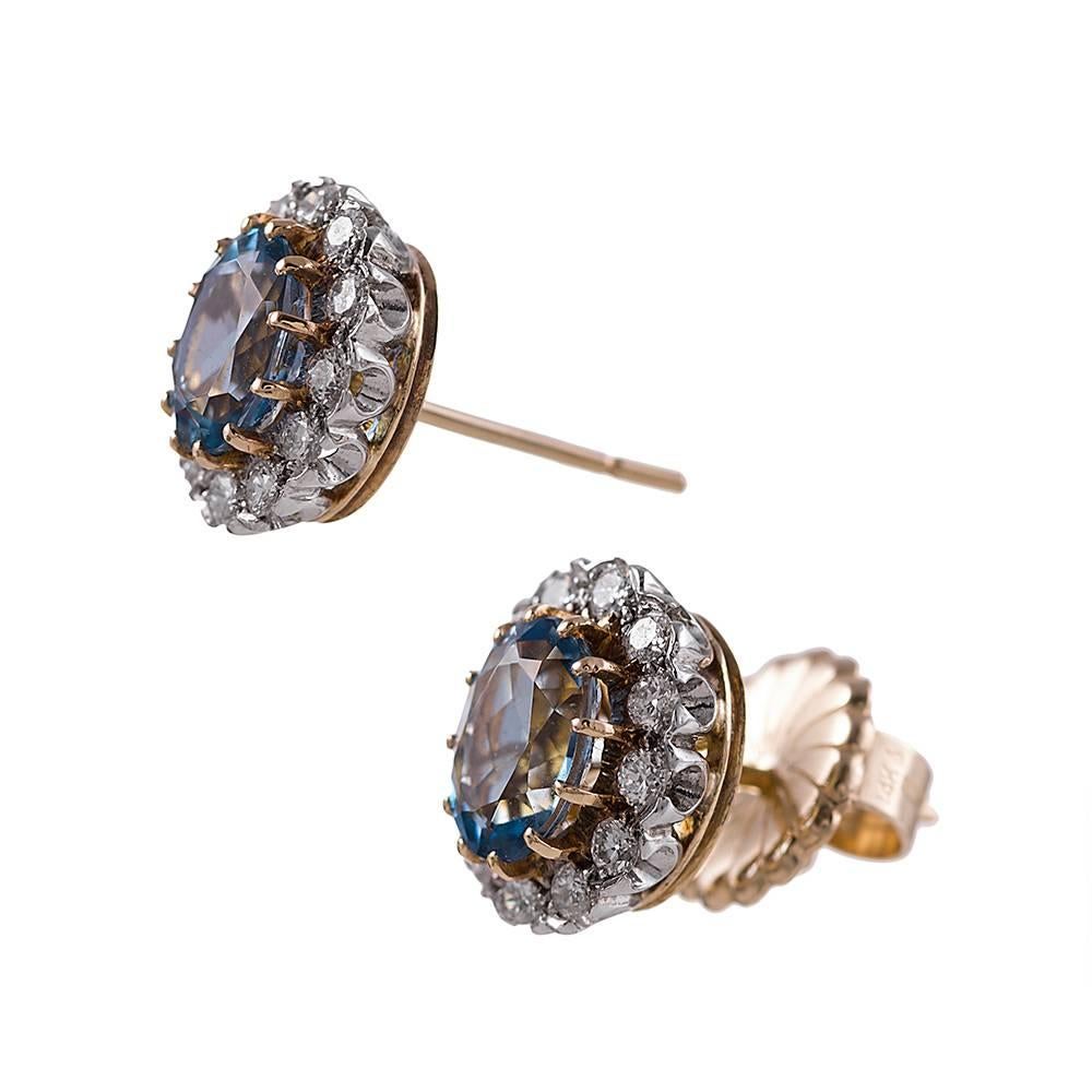 Made of 18k white and yellow gold and set in the center with 2.16 carats of aquamarine, then framed with .60 carats of brilliant round diamonds. These classic studs have a gentle twist, as the center stones are oval. These classic beauties will be