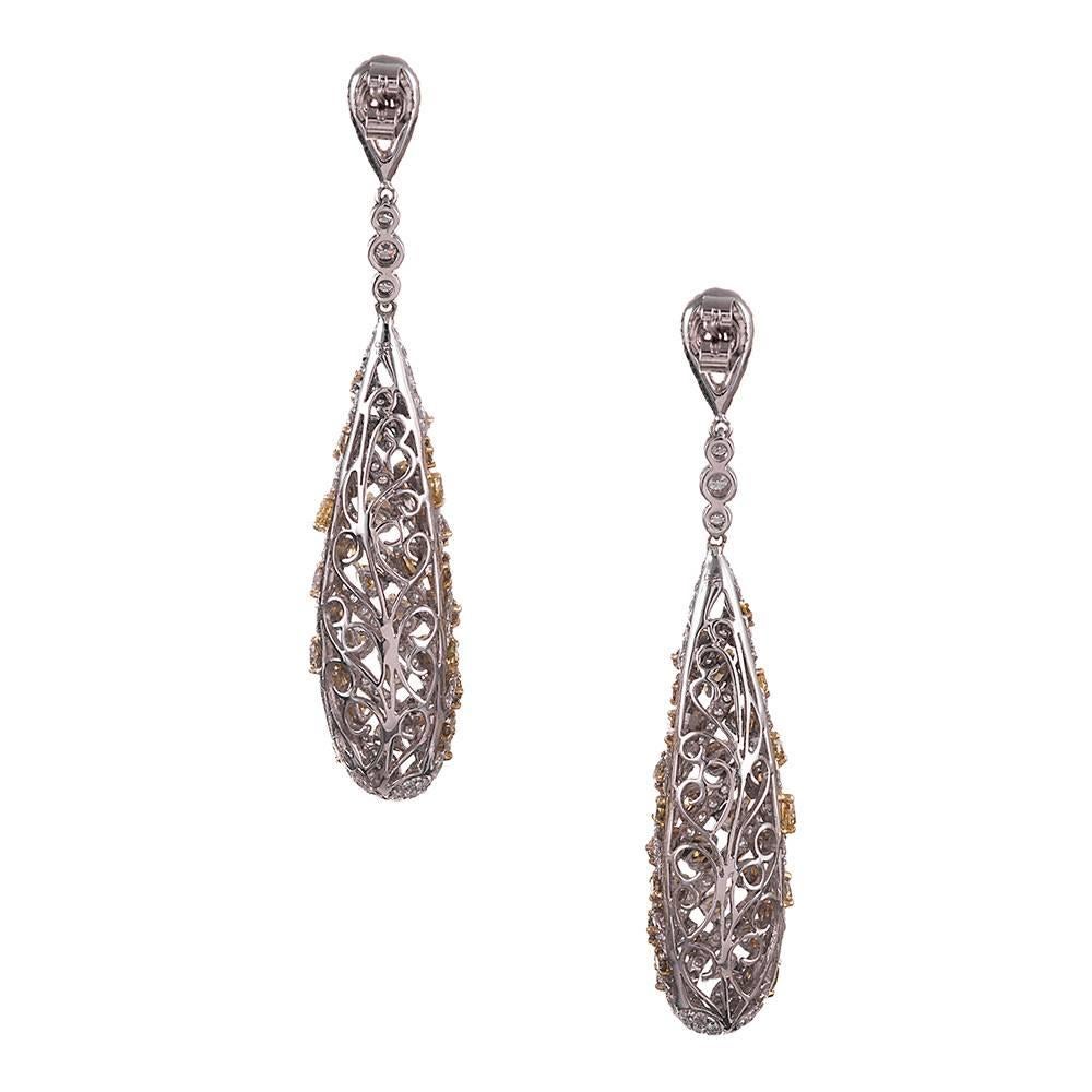 18 karat gold earrings with long, dramatic style, ideal for any formal affair. The front is decorated with rows of fancy colored diamonds, 5.25 carats in total, and separated by stripes of brilliant white diamonds. The white diamonds weigh 4.57