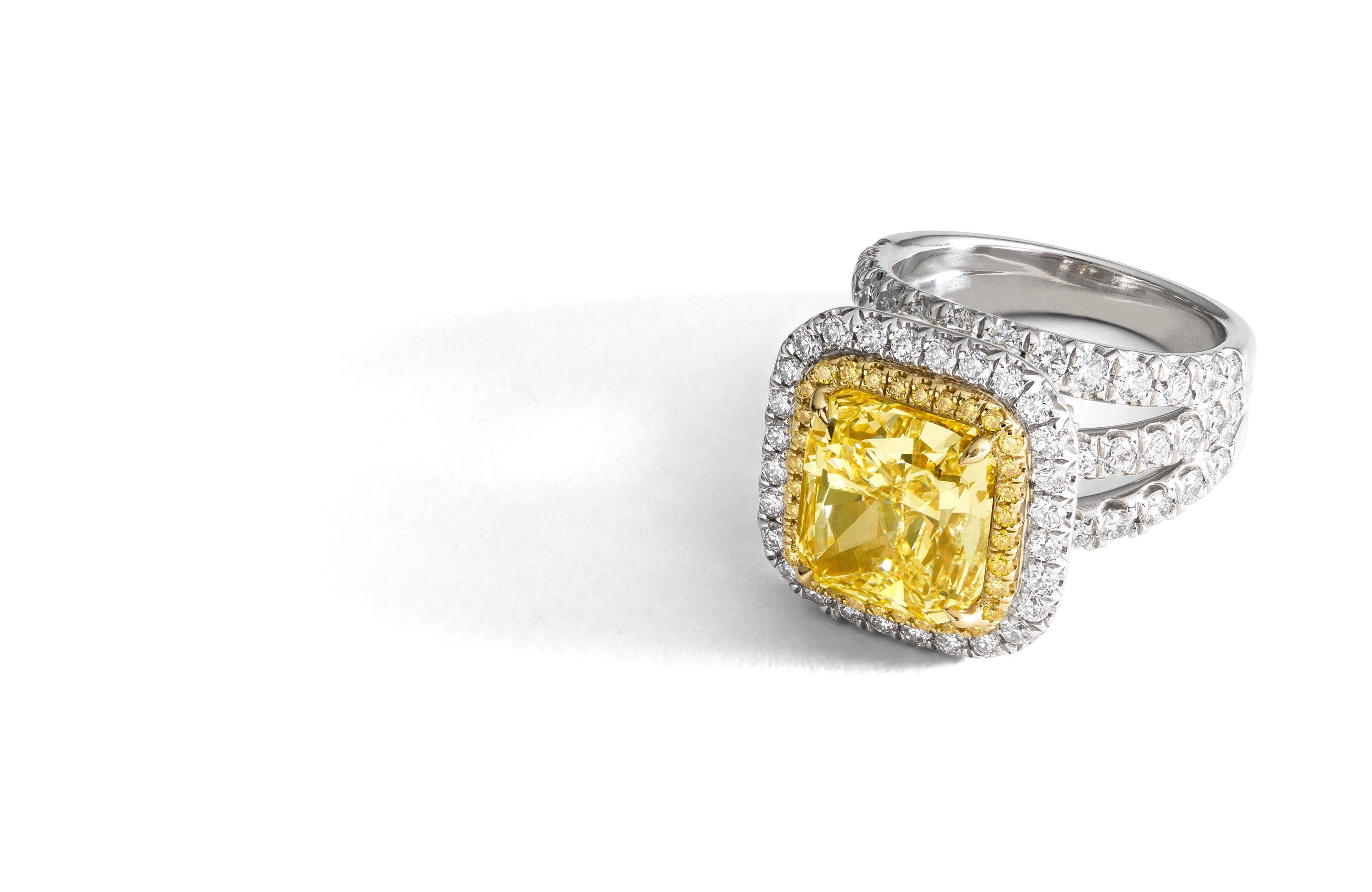 This mesmerizing and stunning ring features a rare 6.30 carat radiant-cut Fancy Light Yellow diamond surrounded by Fancy Yellow diamonds, and round brilliant and pear-shaped white diamonds. Set in platinum and 18K gold, the center stone is GIA