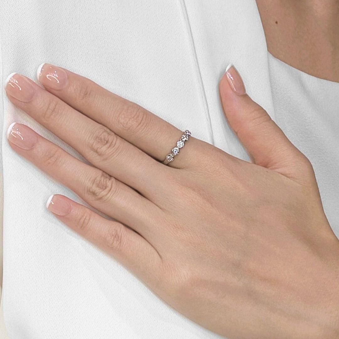 Indossa il luccichio senza tempo di questo squisito anello, realizzato con cura in oro bianco 18 carati, sulla tua mano.  Cinque splendidi diamanti rotondi naturali per un totale di 0,25 carati sono incastonati in questa elegante fascia.  Una linea