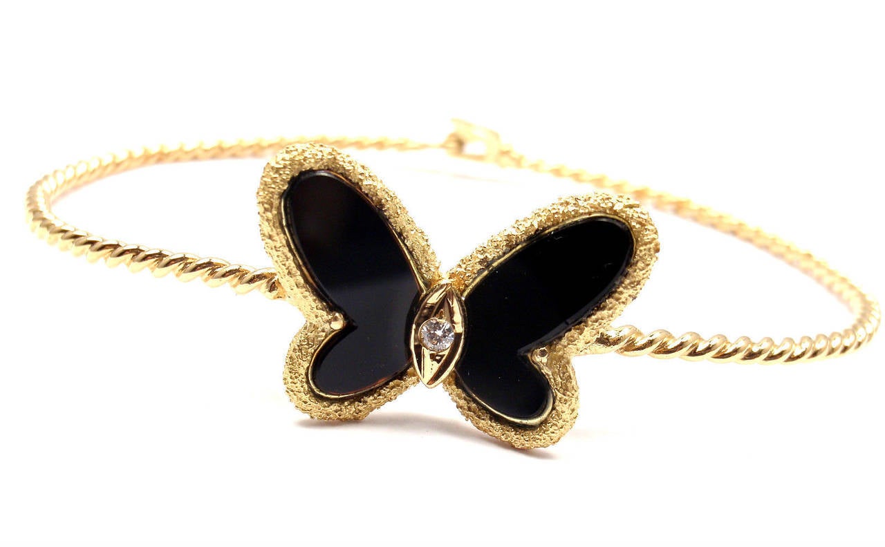 18k Yellow Gold Diamond Onyx Butterfly Bangle Bracelet by Van Cleef & Arpels. 
With 1 round brilliant cut diamond VS1 clarity, G color total weight .06ct
Butterfly Onyx 

Details:
Length: 7