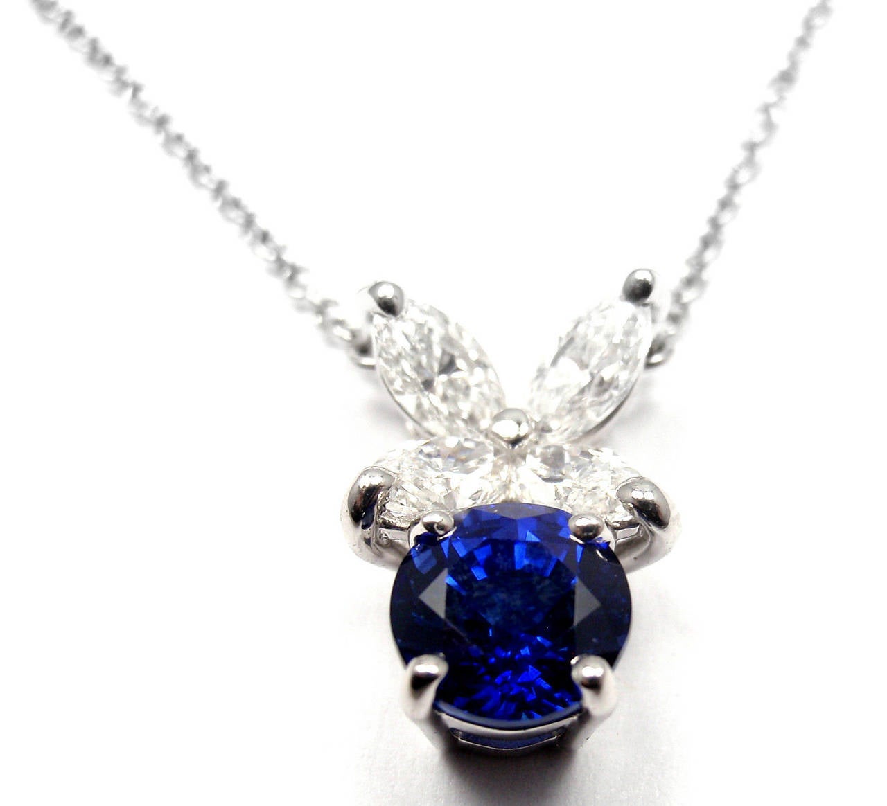 Platinum Victoria Diamond and Sapphire Pendant Necklace by Tiffany & Co. 
With 4 marque shape brilliant cut diamonds  
t/w = .60ct  VS1 clarity F color
1 round sapphire approx. 1ct

Details: 
Weight: 3.9 grams
Length: 16