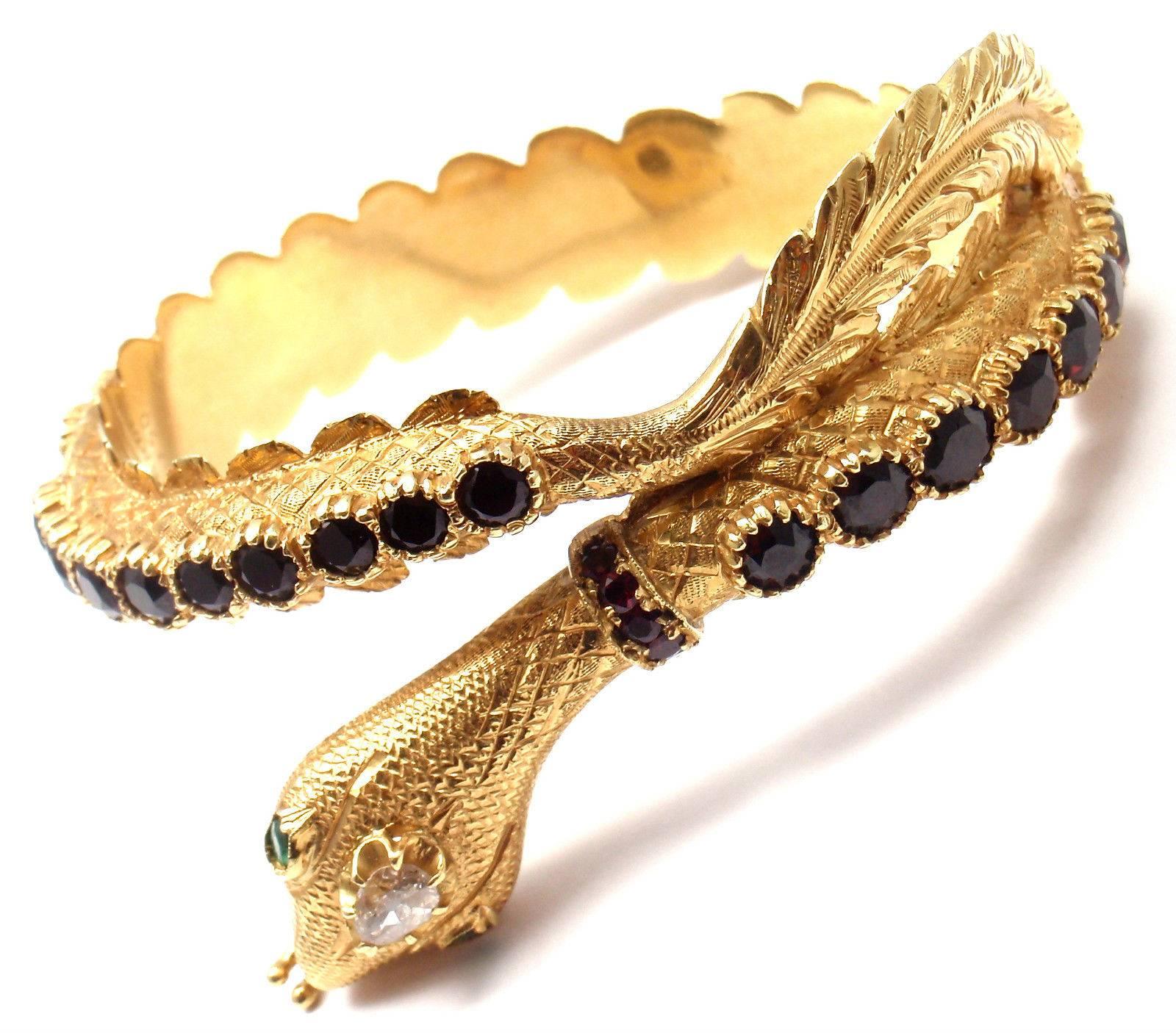 18k Yellow Gold Garnet Diamond Emerald Bangle Bracelet by Giulio Nardi.  
With 32 round garnets
1 rose cut diamonds
2 small emeralds in the eyes

Details:  
Length: 7