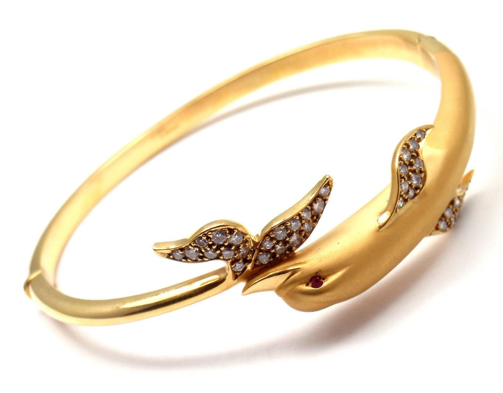 18k Yellow Gold Dolphin Diamond Bangle Bracelet by Carrera Y Carrera.
With 32 round brilliant cut diamonds VS1 Clarity G Color total weight approx. .50ct
2 small rubies

This bracelet comes with Box and Certificate. 

Details:
Length: