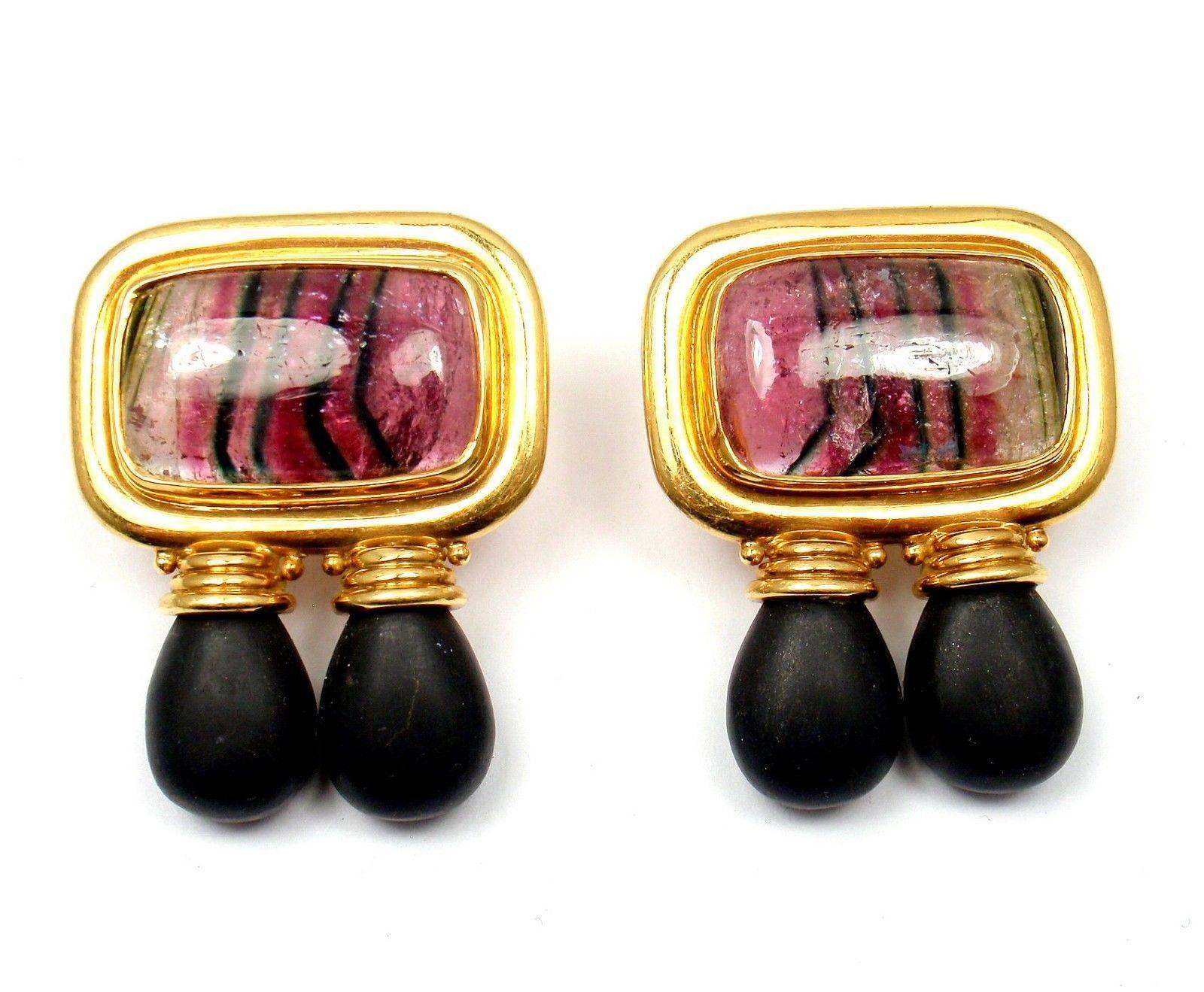 18k Yellow Gold Ebony Wood And Watermelon Tourmaline Earrings by Elizabeth Gage. 
With 2x Watermelon Tourmalines: 13mm x 22mm
4x Ebony Wood Pieces: 8mm x 10mm x 12mm

Details:
Measurements: 31mm x 39.5mm
Weight:  43.4 grams
These earrings are to non