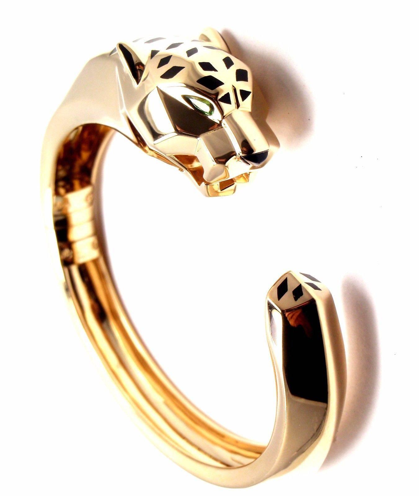 18k Yellow Gold Panther Panthere Tavorite Onyx Large Size Panther Bangle Bracelet by Cartier.
With 2 Tsavorite Garnets in the eyes, 1 black onyx nose and black lacquer.
This beautiful bracelet comes with its original Cartier box.

Details:
Size: