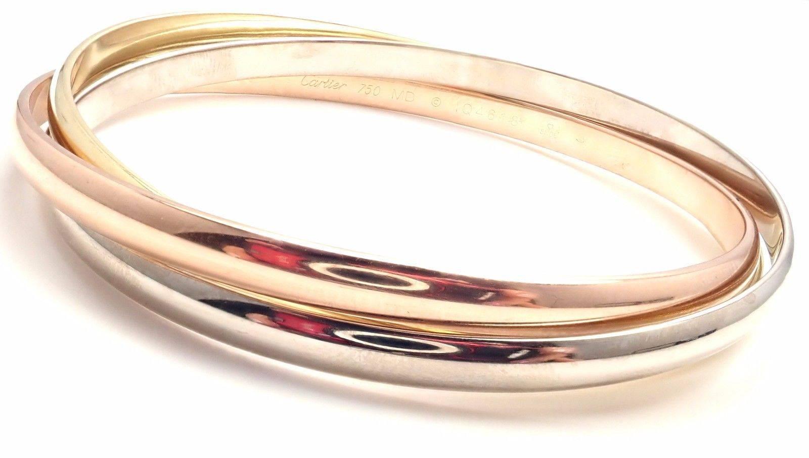 18k Tri-Colored Gold (Yellow, White, Rose) Trinity Rolling Bangle Bracelet by Cartier. 
This is a medium sized bangle. 
Details: 
Length: 7