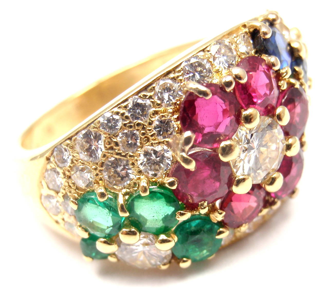18k Yellow Gold Ring by Van Cleef & Arpels. 
With 34 diamonds at approximately 1.25ct total weight. VVS1 clarity, G color
4 sapphires at approximately .50ct total weight
4 emeralds at approximately .50ct total weight
6 rubies at approximately