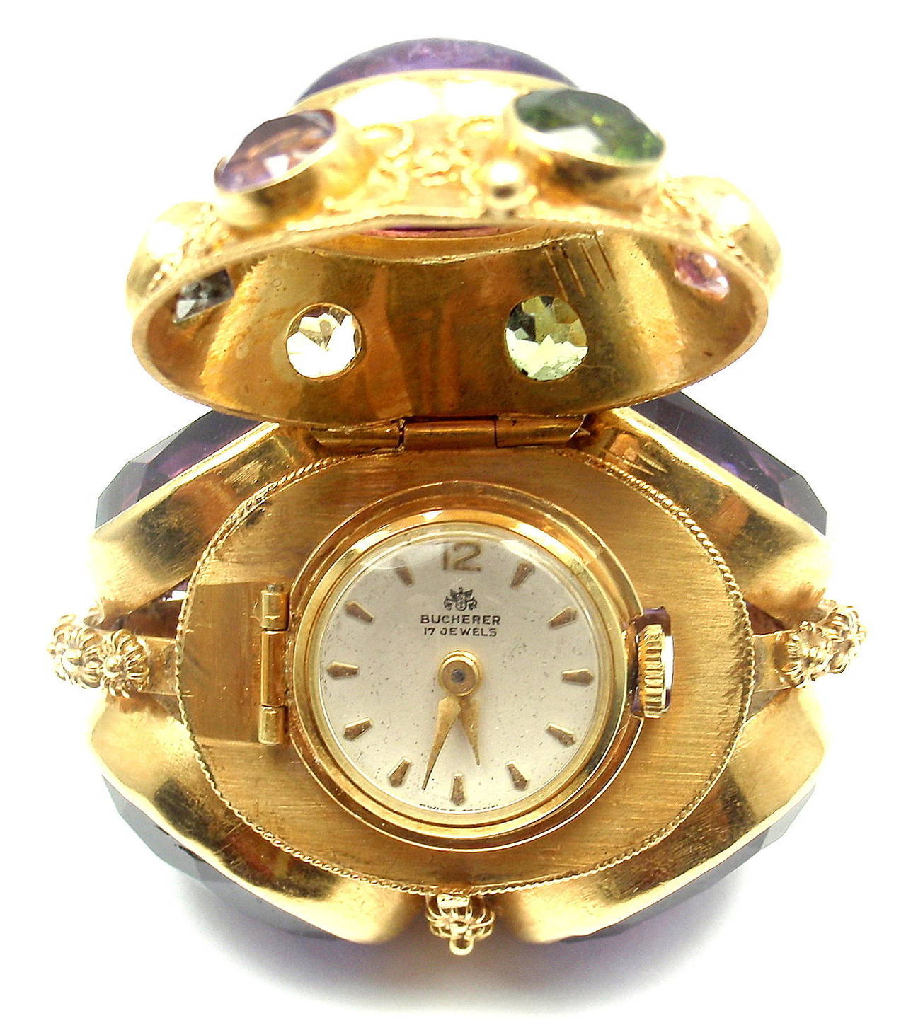 18k Yellow Gold Amethyst Pearl Large Pendant Watch by Bucherer. 
The bottom of the pendant flips open to reveal a lovely Bucherer watch. 
Brand:  Bucherer
Movement: 17 jewels wind up movement.
The watch is in great working condition.

With 4