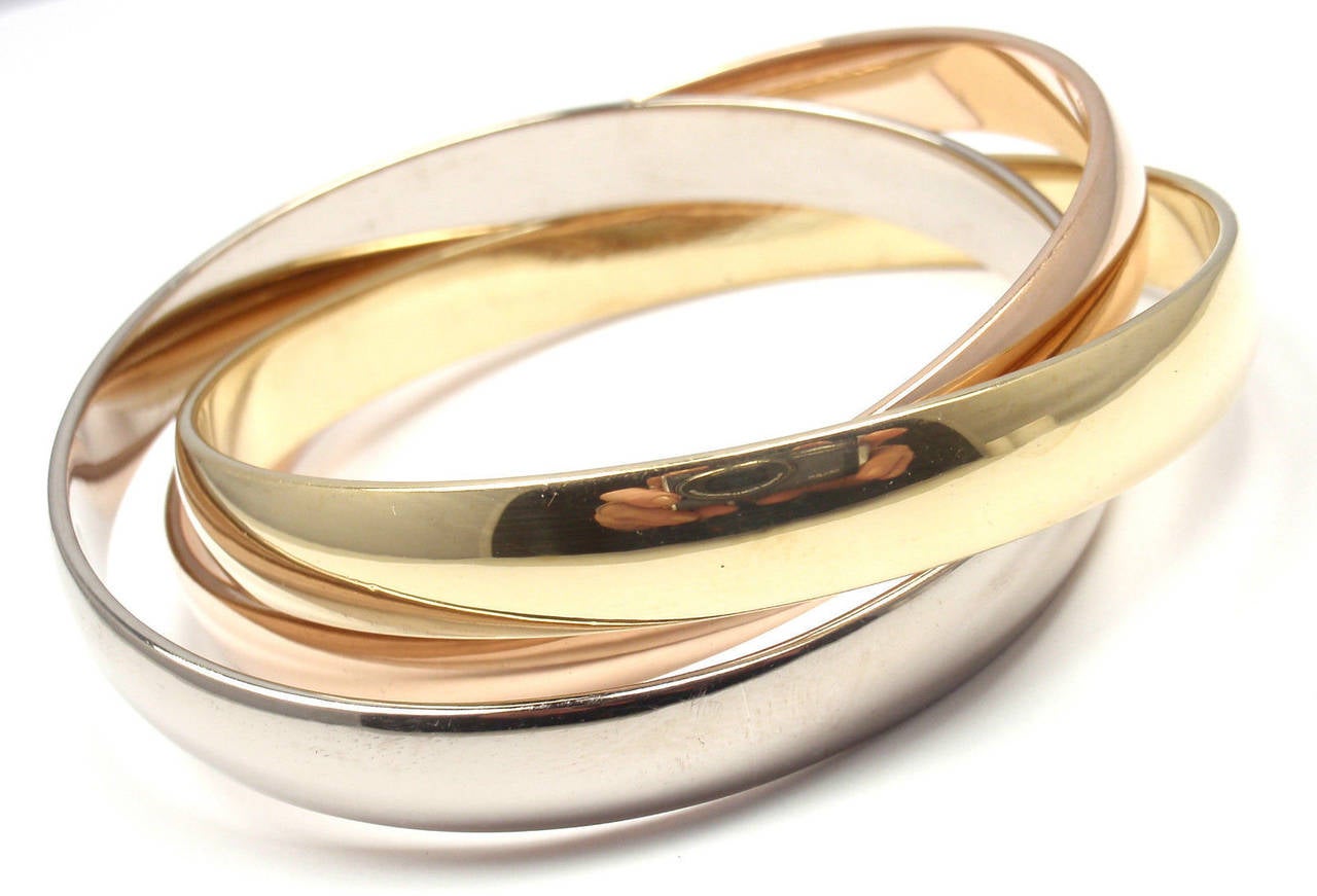 18k Tri-Colored Gold (Yellow, White, Rose) Trinity Rolling Large Model Bangle Bracelet by Cartier.
This beautiful Cartier Trinity Bangle comes with Cartier box and Cartier certificate.

Details:
Length: Medium - 7
