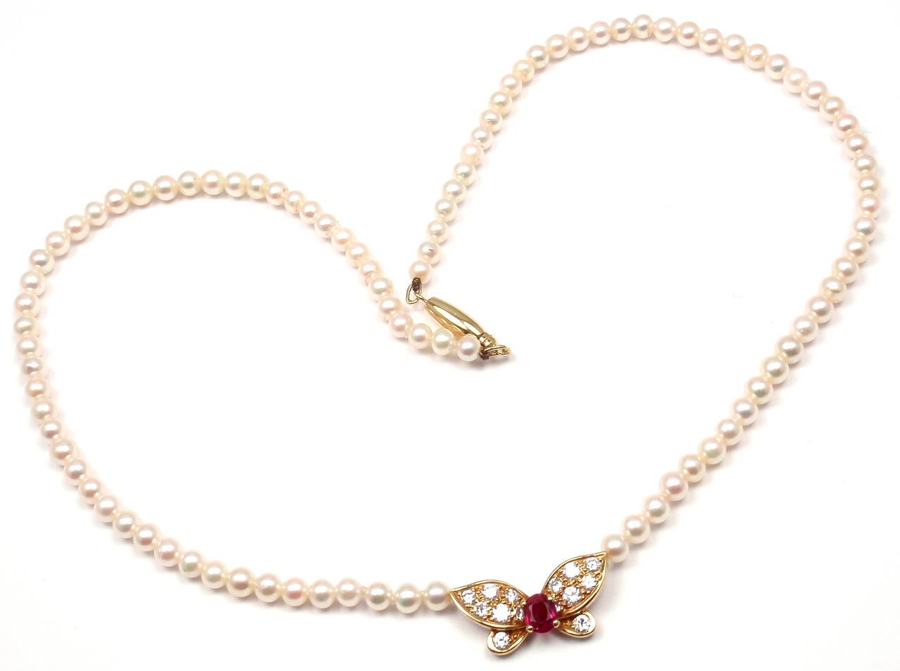 18k Yellow Gold Diamond Ruby Pearl Butterfly Necklace by Van Cleef & Arpels. With 14 round brilliant cut diamonds VS1 clarity, G color total weight .51ct
1 ruby total weight .33ct
95 cultured pearls 4mm each

Details: 
Length: 15.5''
Butterfly