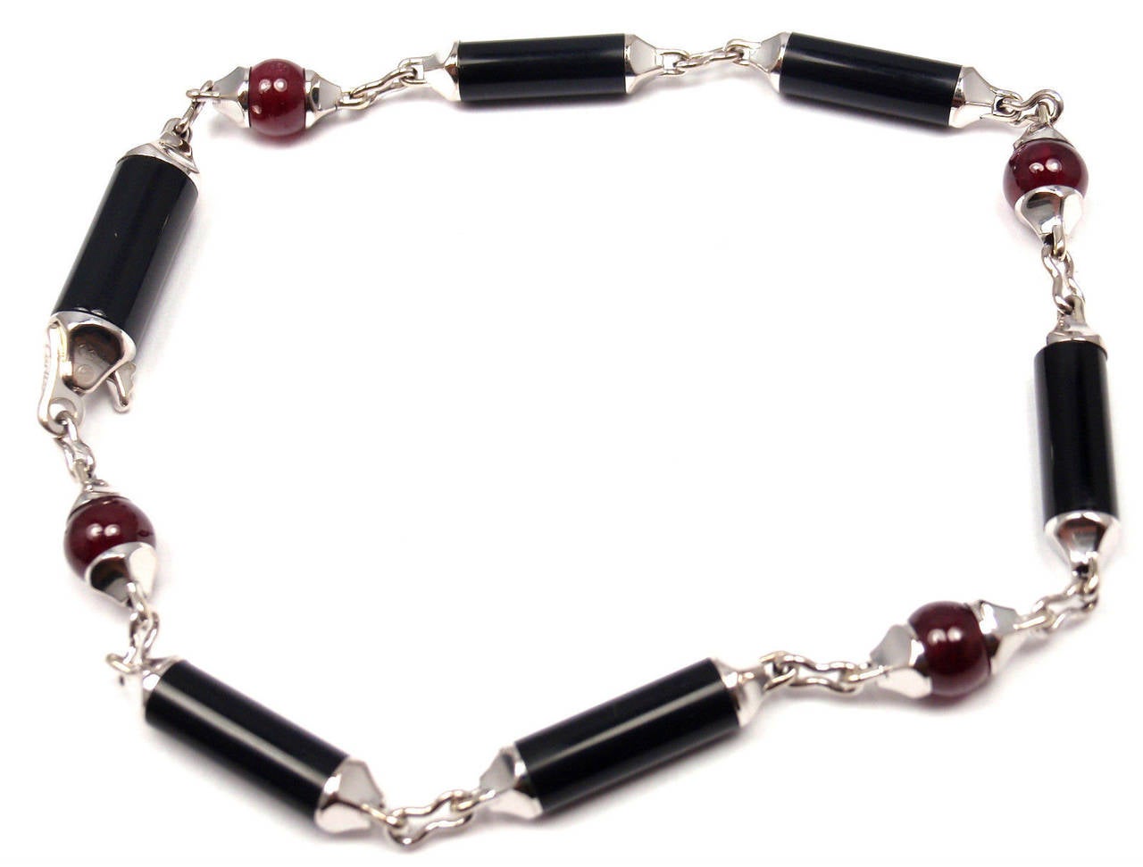18k White Gold Ruby & Onyx Bracelet by Cartier. 
Part of the Cartier Le Baiser Du Dragon Collection. 
With 6 pieces of onyx bars 12mm x 4mm each
4 5mm ruby beads

Details: 
Weight:  10.9 grams
Length: 7.5 inches 
Width: 5mm
Stamped